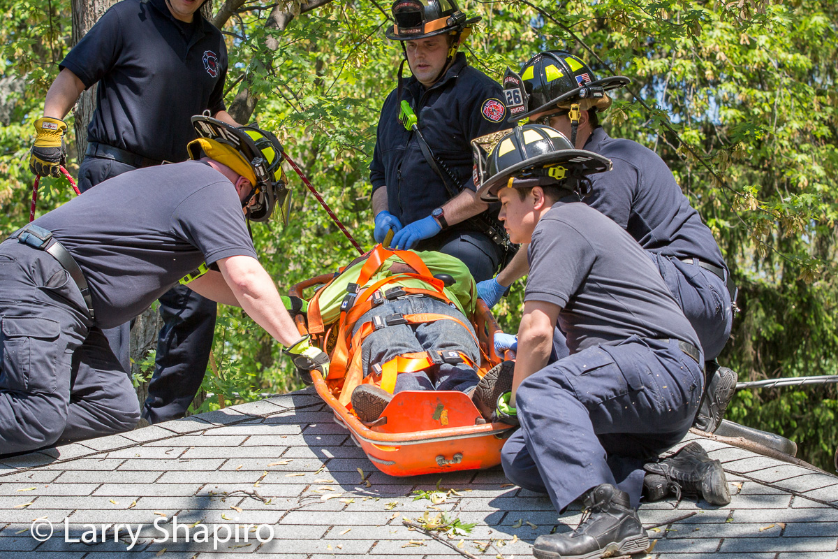 Buffalo Grove firemen rescue a tree worker that fell 30 feet onto a garage roof at 271 Lincoln Terrace 5-21-15 Larry Shapiro photographer shapirophotography.net